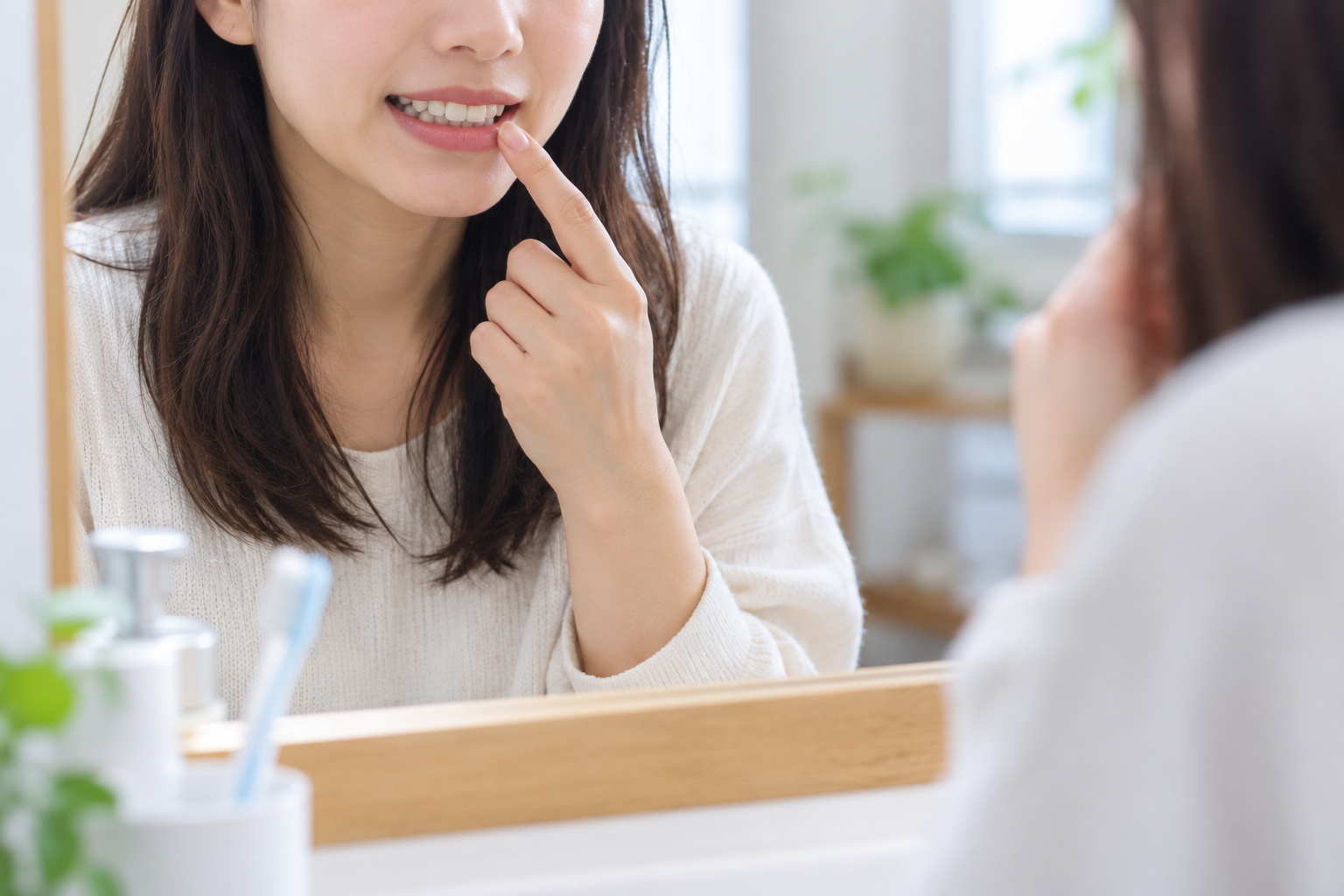 ホワイトニング後の歯の状態を確認する女性